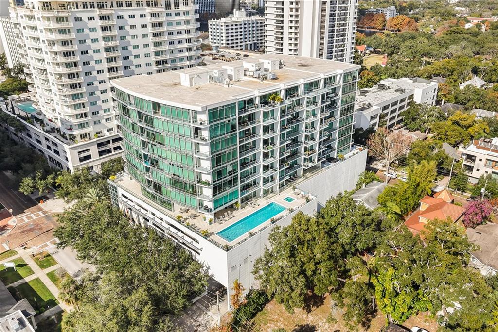 An aerial view shows a modern mid-rise apartment building with a rooftop swimming pool — 101 S EOLA DRIVE UNIT 1010, ORLANDO, FL