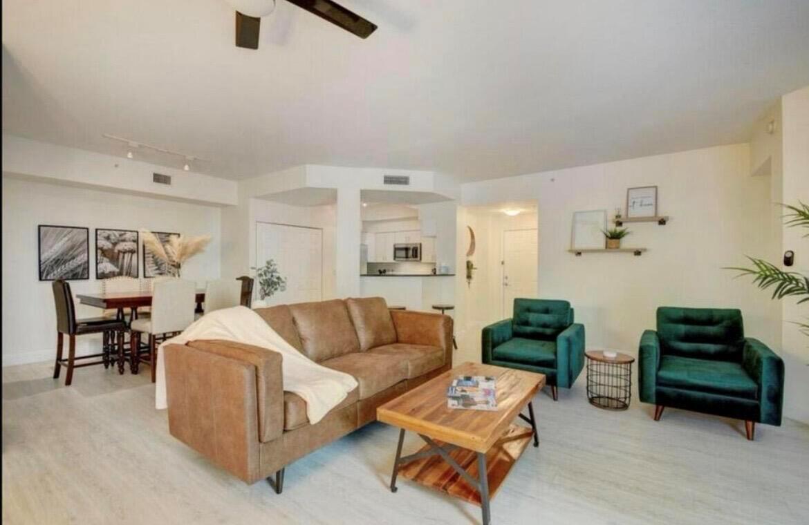 A living room with a brown sofa, two green armchairs, and a wooden coffee table — 802 W Windward Way # 216, Lantana FL 33462, LANTANA, FL