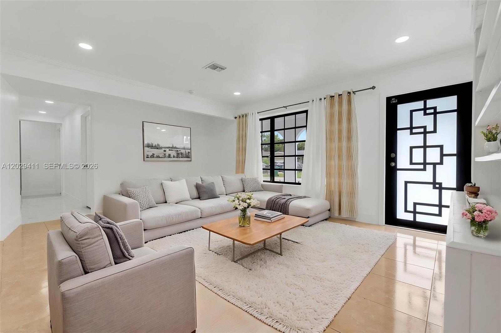 A bright living room features a sectional sofa, a coffee table, and a patterned door — 6101 SW 24th St # 1, Miramar FL 33023, MIRAMAR, FL