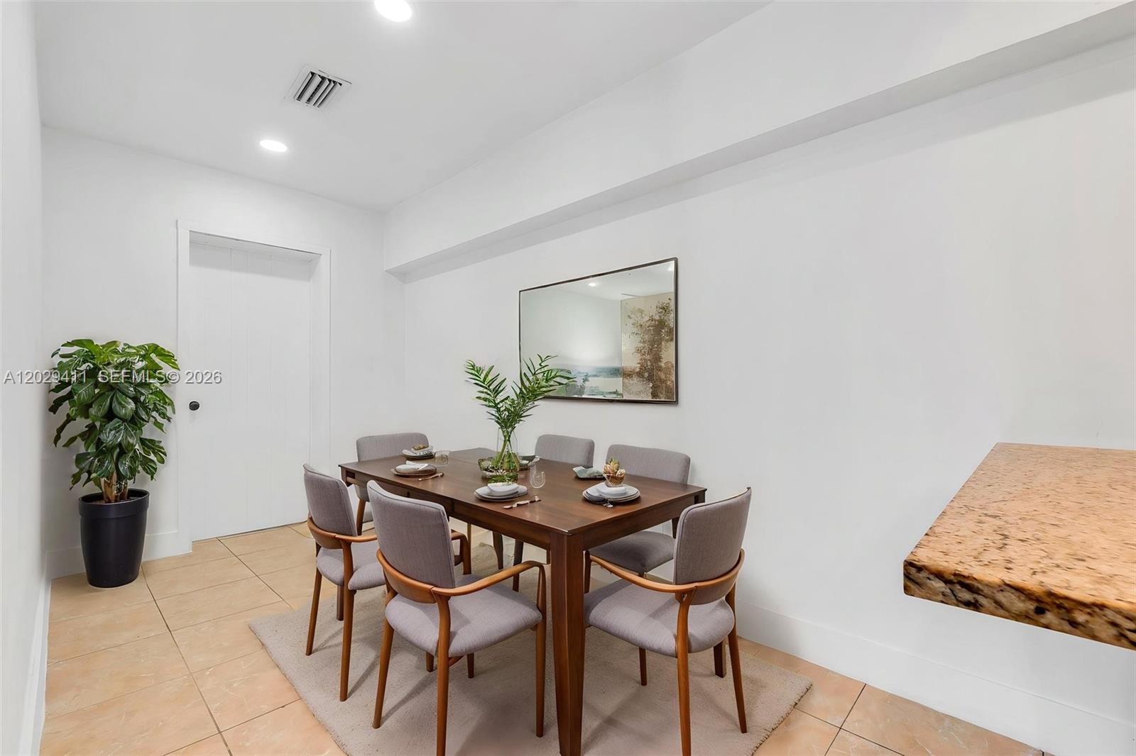 A dining room features a wooden table with six gray chairs on a rug — 6101 SW 24th St # 1, Miramar FL 33023, MIRAMAR, FL