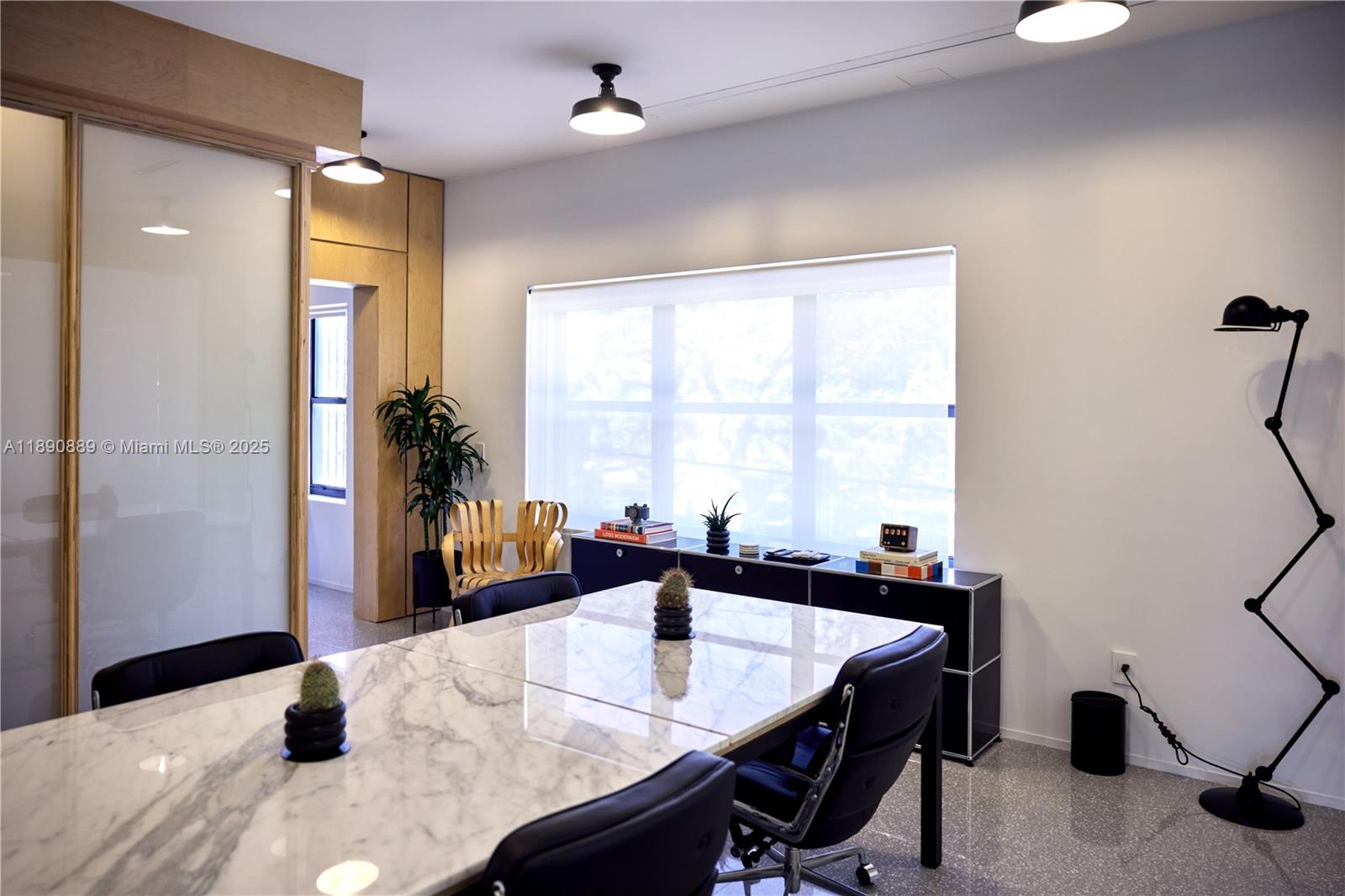 A modern conference room features a marble table, black chairs, and a minimalist floor lamp — 1800 N Miami Ave, Miami FL 33136, MIAMI, FL