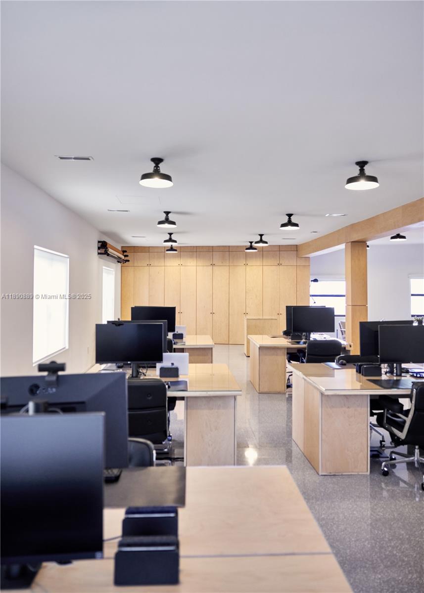 An office space features rows of wooden desks, computer monitors, and light wood cabinetry — 1800 N Miami Ave, Miami FL 33136, MIAMI, FL