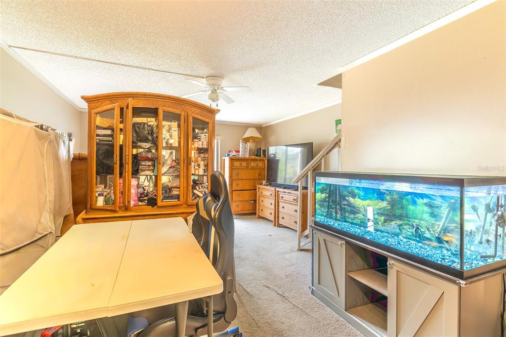 A room features a large fish tank, a wooden display cabinet, and a folding table — 709 RUSSELL LANE UNIT 222, BRANDON, FL