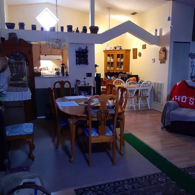 A dining room with a wooden table, chairs, and an open kitchen in the background — 13427 LARAWAY DRIVE, RIVERVIEW, FL