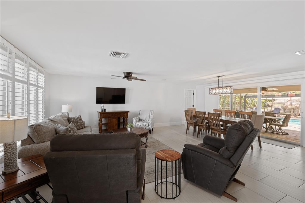 An open-concept living and dining area features tile flooring, a ceiling fan, and patio access — 5215 PELICAN BOULEVARD, CAPE CORAL, FL