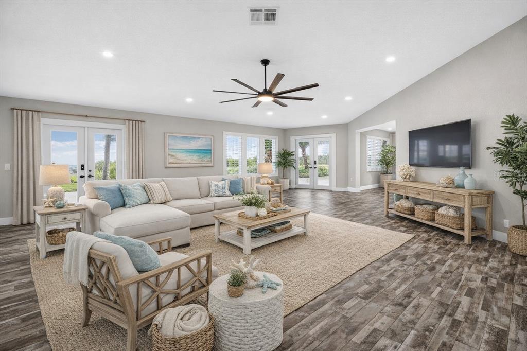 A bright living room features a sectional sofa, wood-look tile flooring, and a ceiling fan — 4111 MARINE PARKWAY, NEW PORT RICHEY, FL