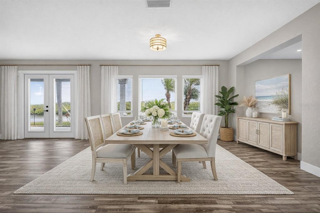 A dining room features a wooden table, upholstered chairs, a sideboard, and large windows — 4111 MARINE PARKWAY, NEW PORT RICHEY, FL