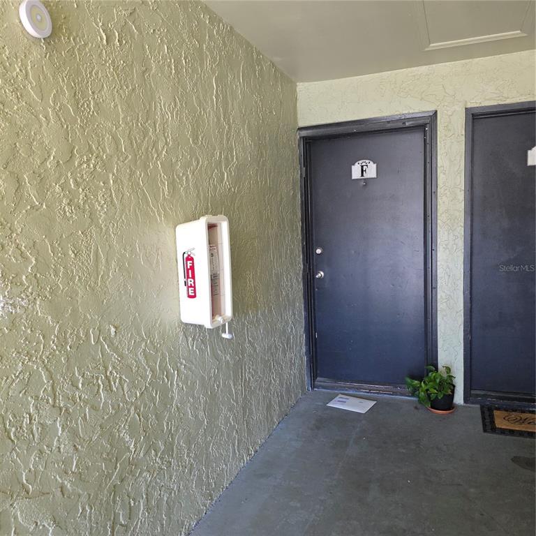 An exterior view of a building entrance with two dark doors and a fire extinguisher cabinet — 922 LAKE DESTINY ROAD UNIT F, ALTAMONTE SPRINGS, FL