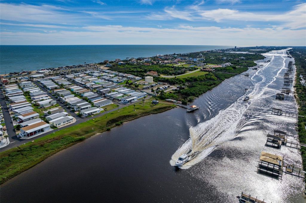 An aerial view shows a coastal mobile home park situated between the ocean and a canal — 191 MONITOR DRIVE, FLAGLER BEACH, FL