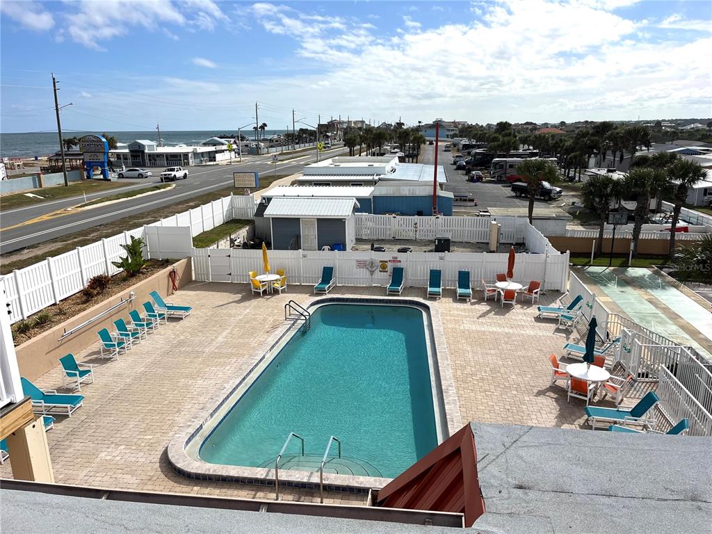An elevated view of a rectangular outdoor swimming pool surrounded by a paved patio area — 191 MONITOR DRIVE, FLAGLER BEACH, FL