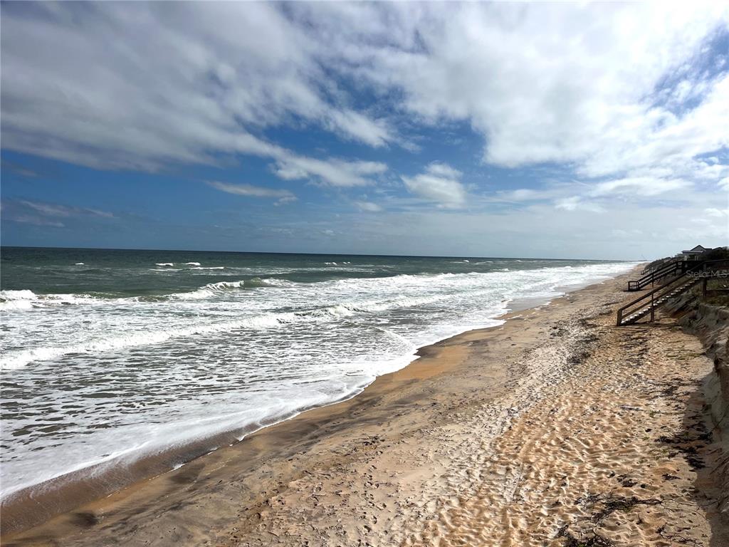 A view of a sandy beach with ocean waves and wooden stairs leading to dunes — 191 MONITOR DRIVE, FLAGLER BEACH, FL