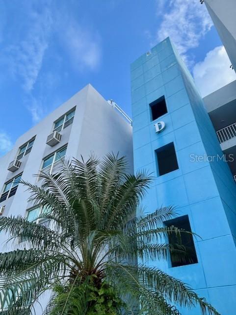 A low-angle view of a blue building labeled D next to a white apartment building — CHALETS DE SAN PEDRO SAN GABRIEL UNIT 402, FAJARDO, PR