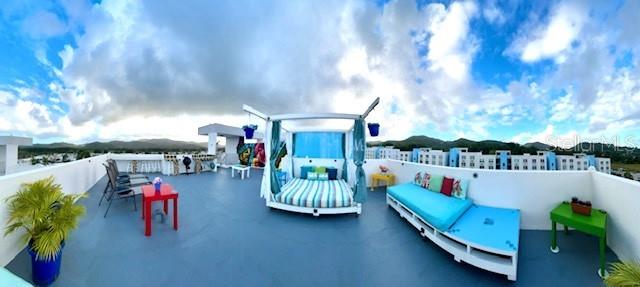 A rooftop terrace features a canopy bed, lounge seating, and a small table under a sky — CHALETS DE SAN PEDRO SAN GABRIEL UNIT 402, FAJARDO, PR