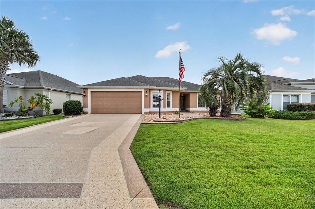 A single-story house with a tan garage, a paved driveway, and a front lawn — 726 BRADFORD LOOP, THE VILLAGES, FL