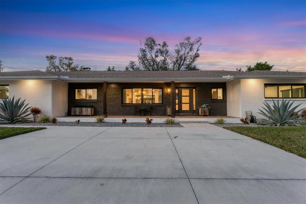 A single-story house with a white exterior, stone facade, and palm trees in the yard — 2411 VALENCIA DRIVE, SARASOTA, FL