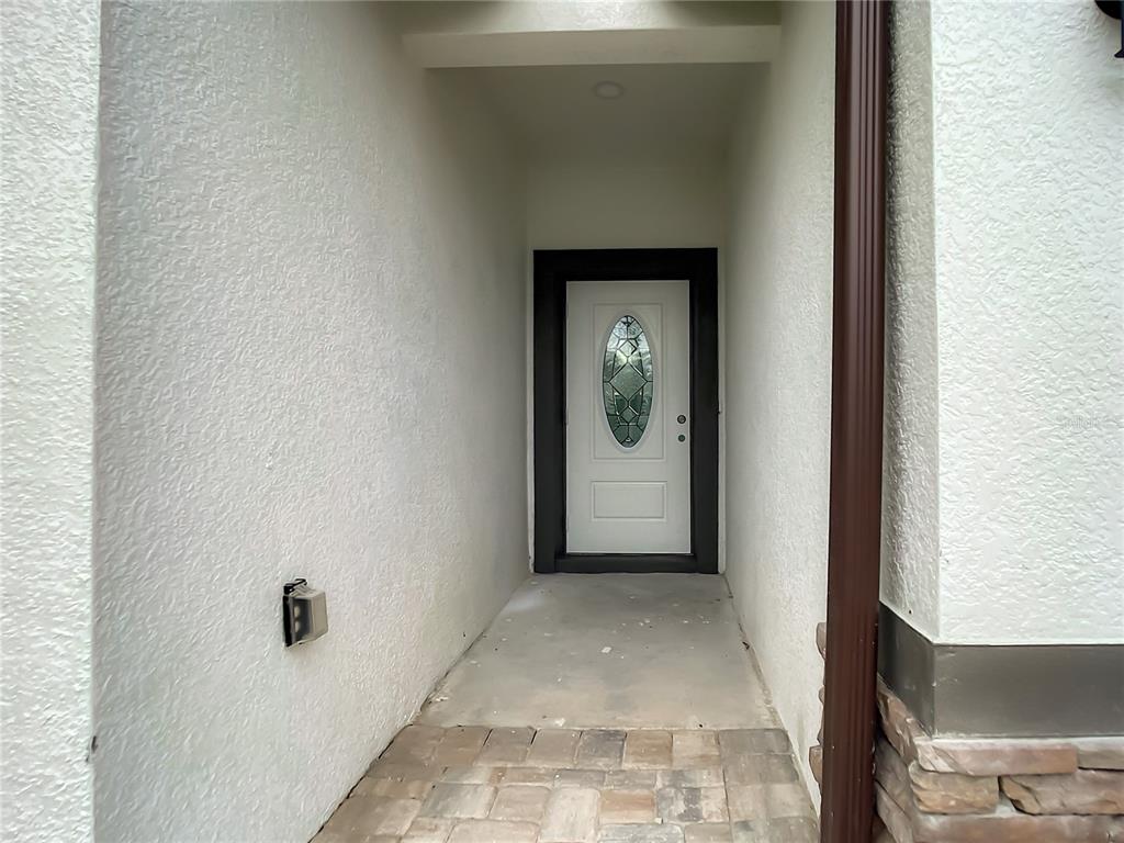 A covered entryway features a white front door with an oval glass insert and pavers — 2109 NORDENDALE BOULEVARD, NORTH PORT, FL