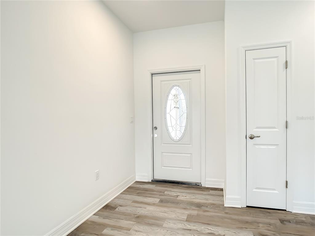An entryway features white walls, wood-look flooring, a front door with a glass insert, and a closet — 2109 NORDENDALE BOULEVARD, NORTH PORT, FL
