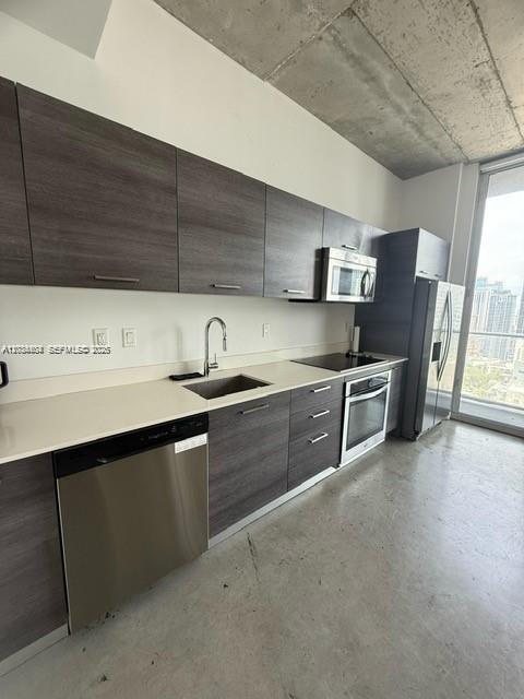 A modern kitchen features dark wood cabinets, stainless steel appliances, and a concrete ceiling — 151 SE 1st St # 2906, Miami FL 33131, MIAMI, FL