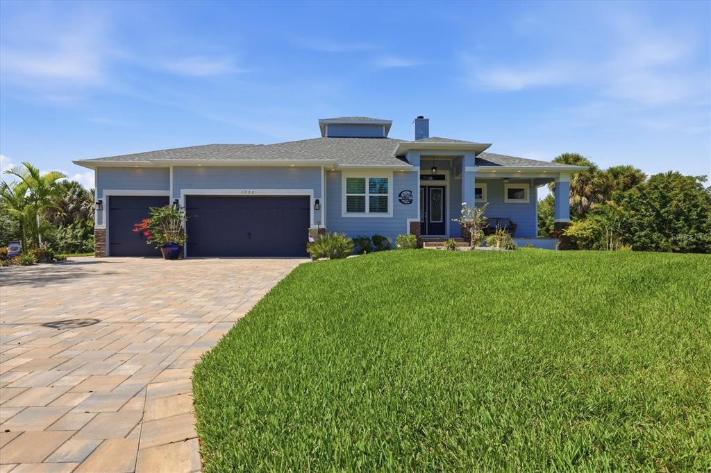 A boat is docked under a covered lift on a canal behind a grassy lawn — 1022 BEEKMAN CIRCLE, PORT CHARLOTTE, FL