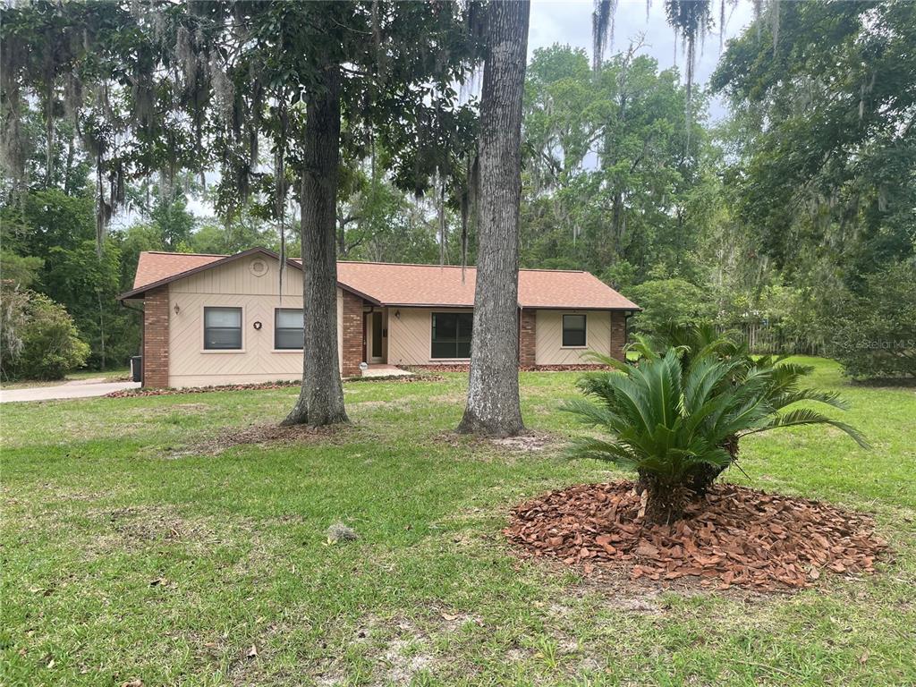 A brick-columned sign for the Hills of Santa Fe neighborhood stands beside a road — 2421 NW 106TH DRIVE, GAINESVILLE, FL