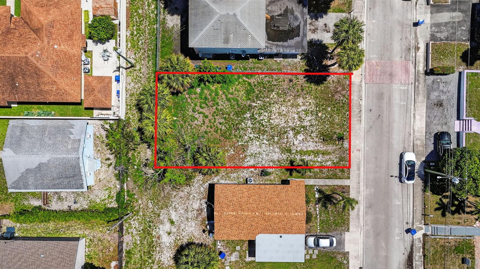 An aerial view shows a vacant rectangular lot outlined in red between two residential houses — 1204 W 35th Street, Riviera Beach FL 33404, RIVIERA BEACH, FL