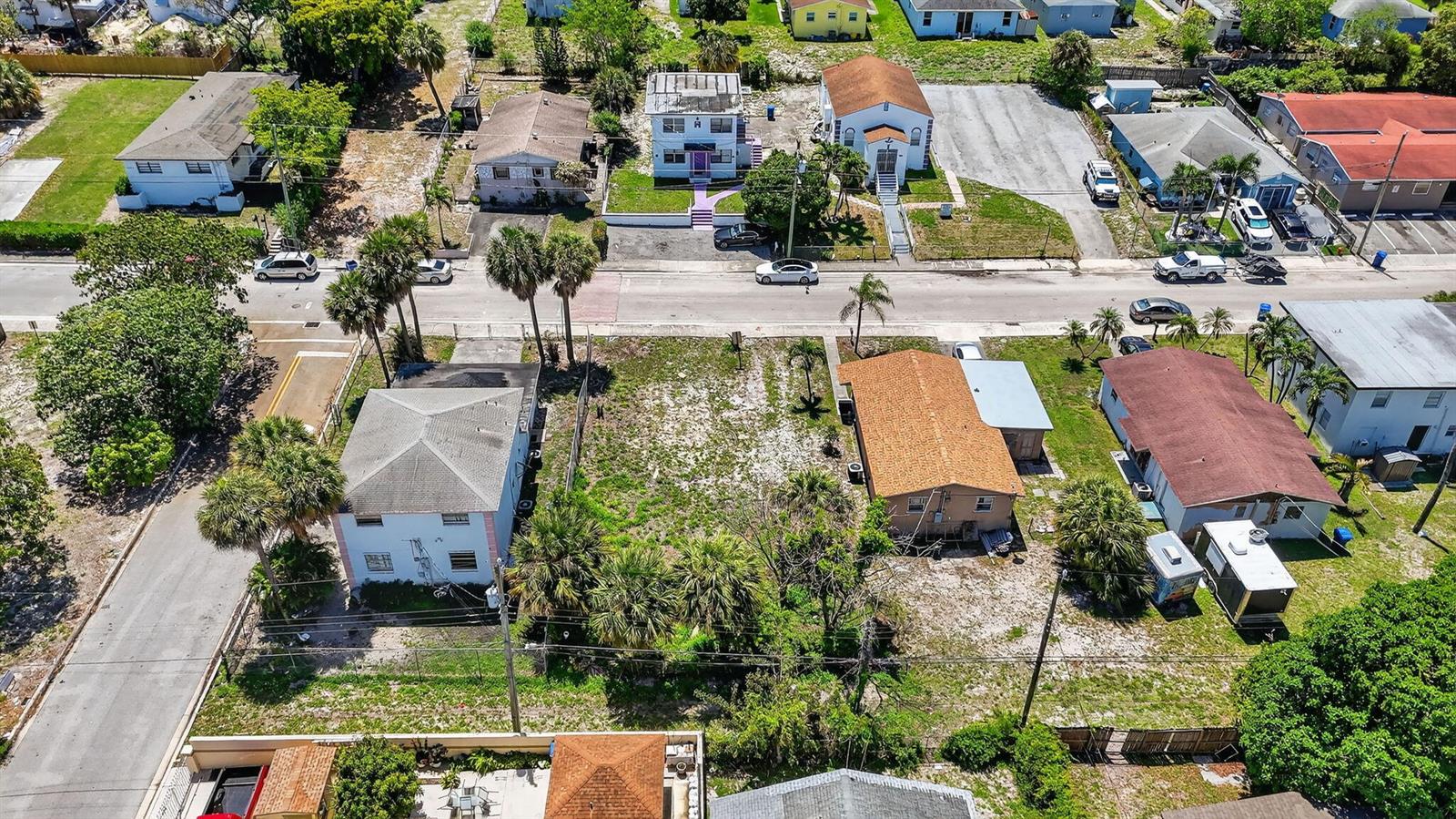An aerial view shows a residential street with several houses and an empty lot — 1204 W 35th Street, Riviera Beach FL 33404, RIVIERA BEACH, FL