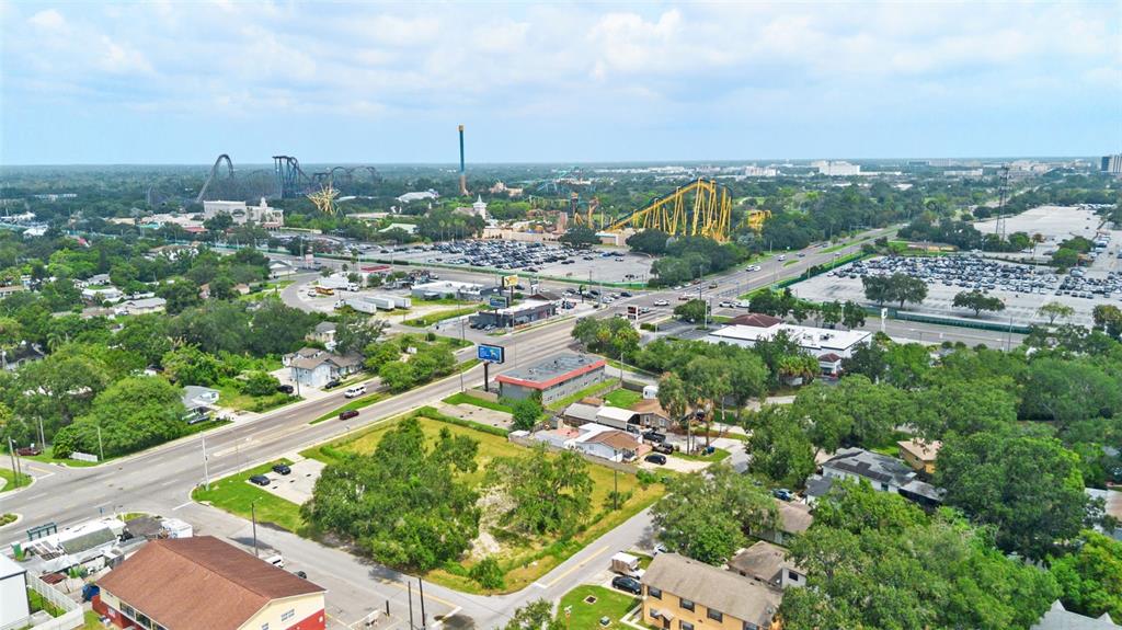 An aerial view shows a residential area near a large amusement park with roller coasters — 8923 N 40TH STREET, TAMPA, FL
