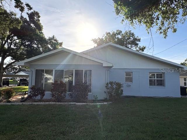 The exterior of a light blue house features a large screened-in porch and white siding — 1902 DANDRIDGE STREET UNIT 12, SUN CITY CENTER, FL