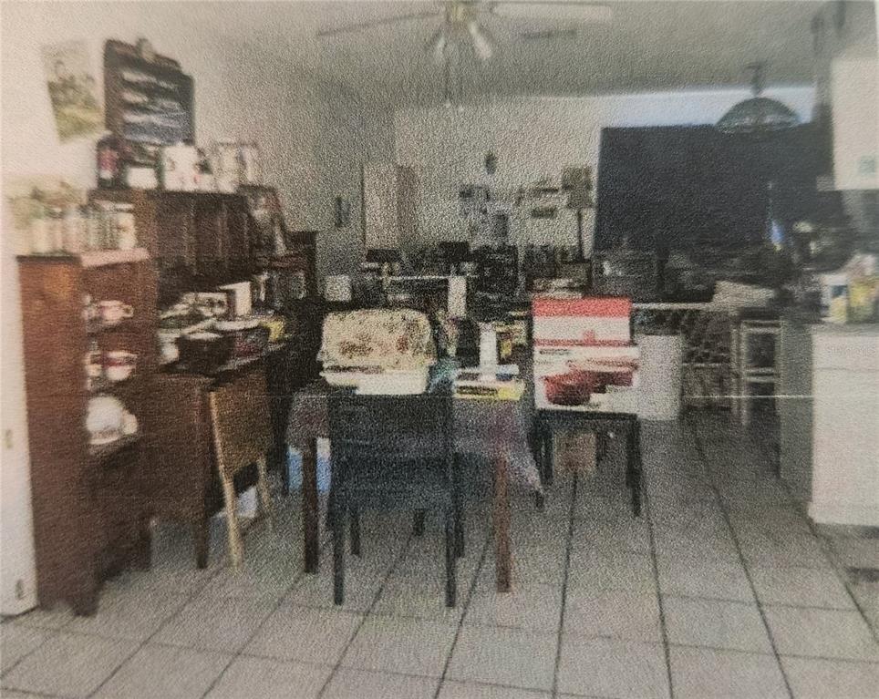 A dining area with tiled floors, a hutch, and a table with chairs — 11234 ELGIN BOULEVARD, SPRING HILL, FL