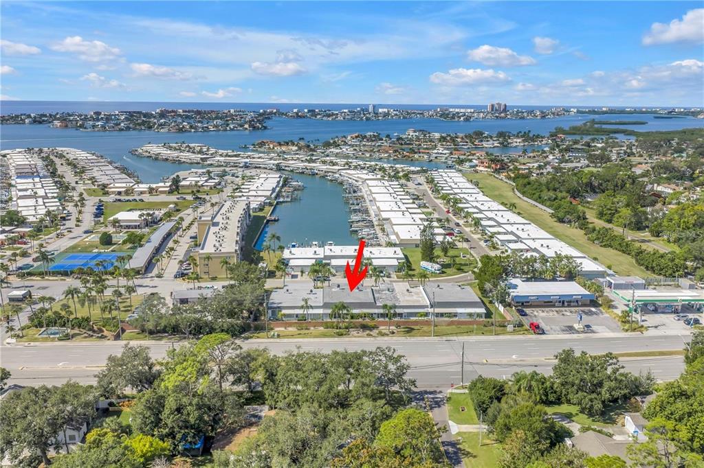 An aerial view shows a low-rise apartment building with a red arrow pointing toward it — 93 BOCA CIEGA POINT BOULEVARD N UNIT 93, ST PETERSBURG, FL