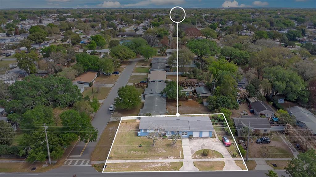 An aerial view shows a single-story house with a blue exterior and a two-car garage — 1951 S CRYSTAL LAKE DRIVE, ORLANDO, FL