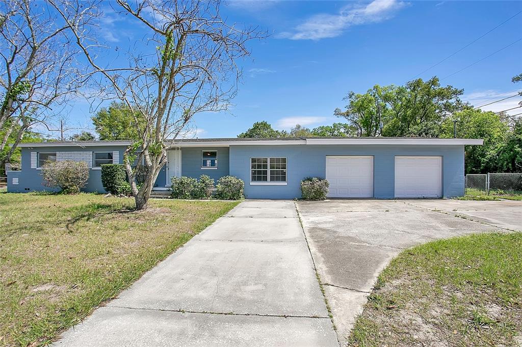A single-story blue house features a two-car garage and a concrete driveway — 1951 S CRYSTAL LAKE DRIVE, ORLANDO, FL