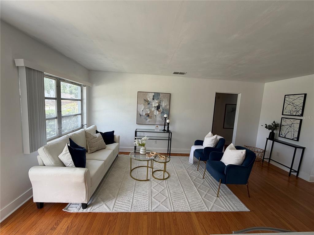 A living room features a white sofa, two navy blue armchairs, and a glass coffee table — 1951 S CRYSTAL LAKE DRIVE, ORLANDO, FL