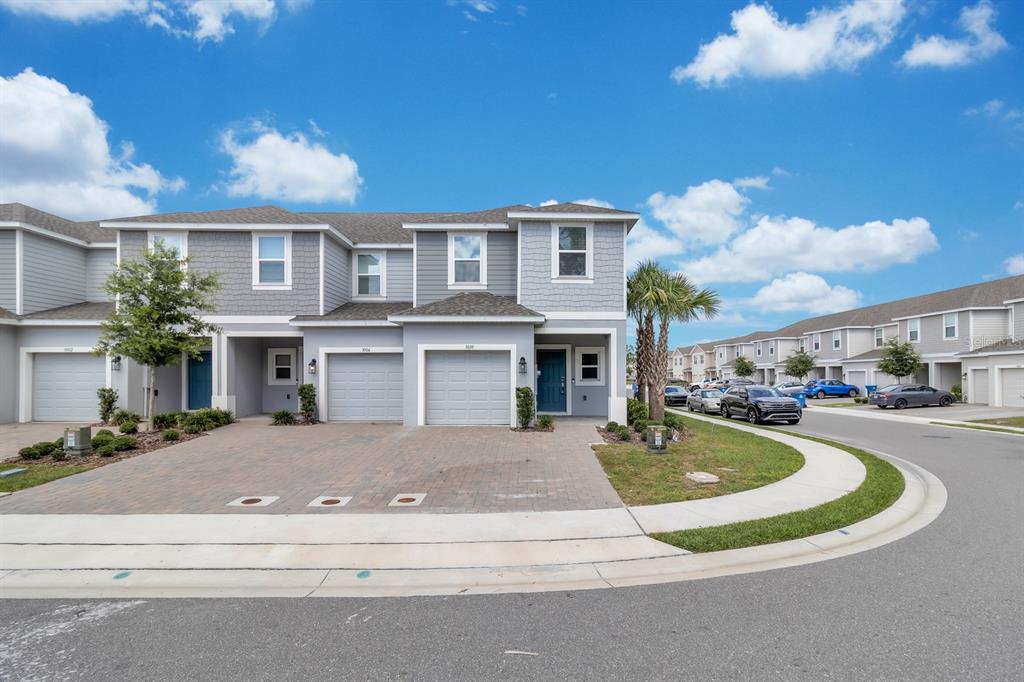 A two-story townhouse with gray siding, a paved driveway, and a two-car garage — 3010 CANARY AVENUE, DAVENPORT, FL