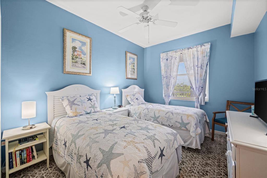 An open-concept living and dining area features light wood flooring, white cabinetry, and a balcony — 10460 WASHINGTONIA PALM WAY UNIT 1342, FORT MYERS, FL