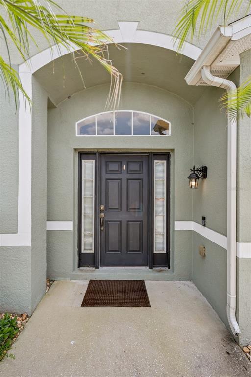A front entryway features a dark door with sidelights, an arched transom, and a lantern — 327 MARATHON LANE, SANFORD, FL