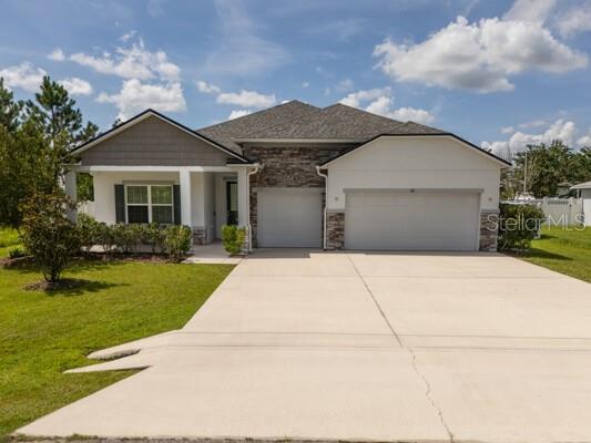 A single-story house with a stone facade, a two-car garage, and a covered front porch — 21 LANCELOT DRIVE, PALM COAST, FL