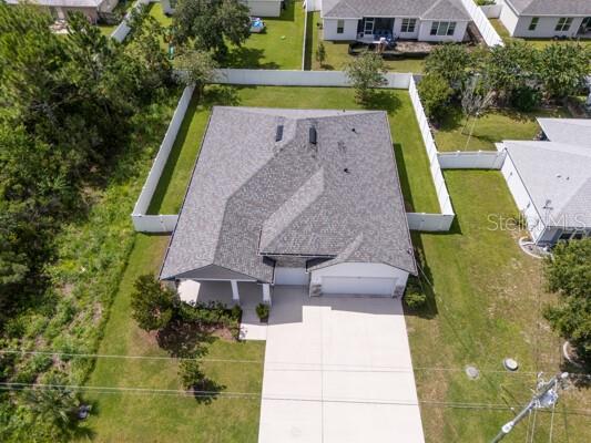 An aerial view shows a single-story house with a gray roof and a concrete driveway — 21 LANCELOT DRIVE, PALM COAST, FL