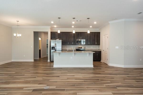 A kitchen with dark wood cabinets, a granite island, and wood-look tile flooring — 21 LANCELOT DRIVE, PALM COAST, FL