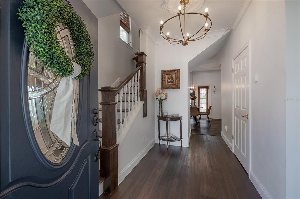 A foyer features dark wood flooring, a staircase with a wooden banister, and a chandelier — 502 E AMELIA AVENUE, TAMPA, FL