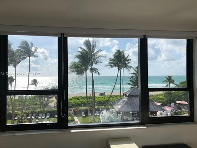 A window view shows a beach, palm trees, and a resort pool area — 5225 Collins Ave # 501, Miami Beach FL 33140, MIAMI BEACH, FL
