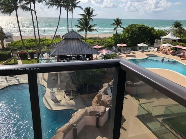 An elevated view shows a swimming pool, a covered pavilion, and the ocean beyond — 5225 Collins Ave # 501, Miami Beach FL 33140, MIAMI BEACH, FL