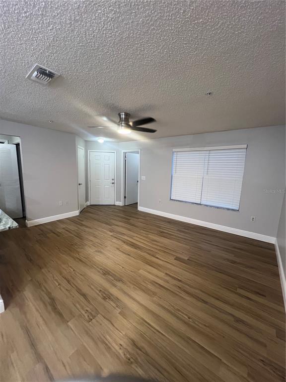 An empty room features light gray walls, wood-look flooring, a ceiling fan, and a window with blinds — 956 SALT POND PLACE UNIT 204, ALTAMONTE SPRINGS, FL