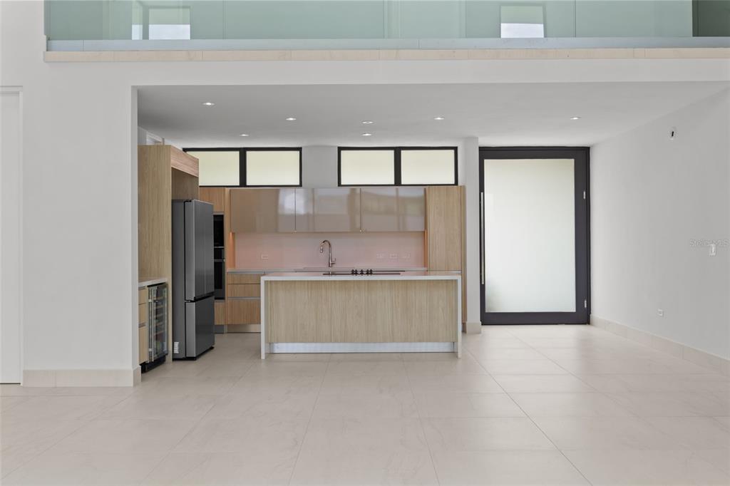A modern kitchen features light wood cabinetry, a central island, and stainless steel appliances — RIVIERA PARKVIEW 135 SALONGA STREET, BAYAMON, PR