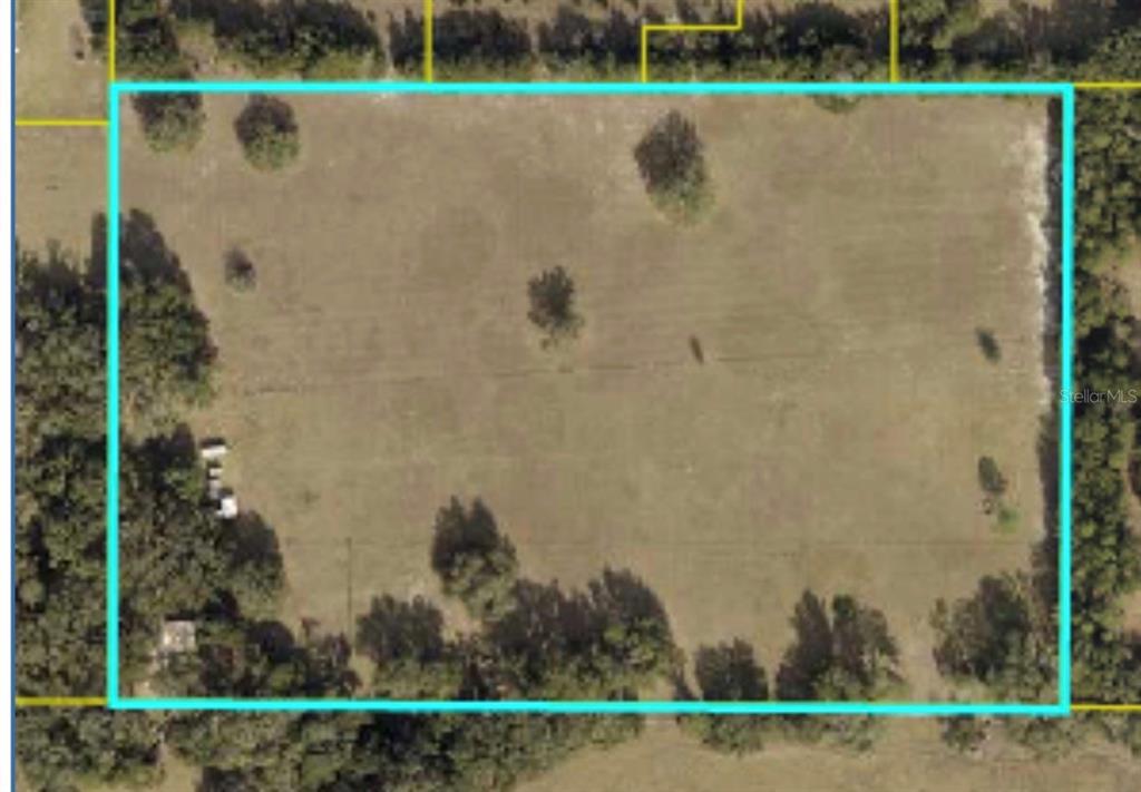 An aerial view shows a rectangular, grassy plot of land outlined in light blue — PARCEL "A" CR 543, SUMTERVILLE, FL