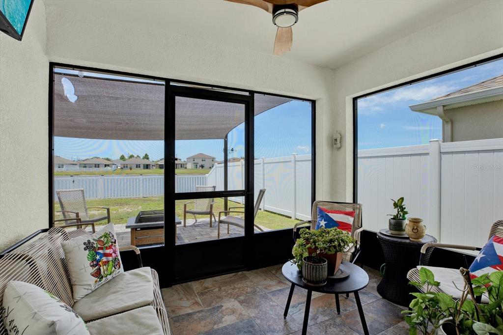 A view of a pond with a fountain behind a white fence and grassy yard — 1013 TIDAL ROCK AVE, RUSKIN, FL