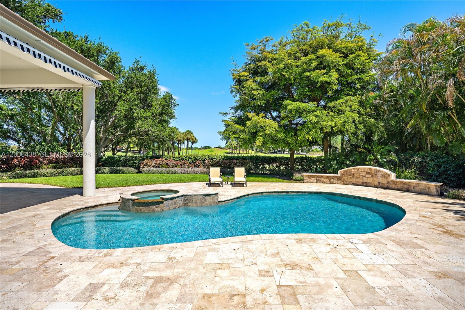A backyard features a swimming pool with an attached spa, stone decking, and lounge chairs — 106 Commodore Dr, Jupiter FL 33477, JUPITER, FL