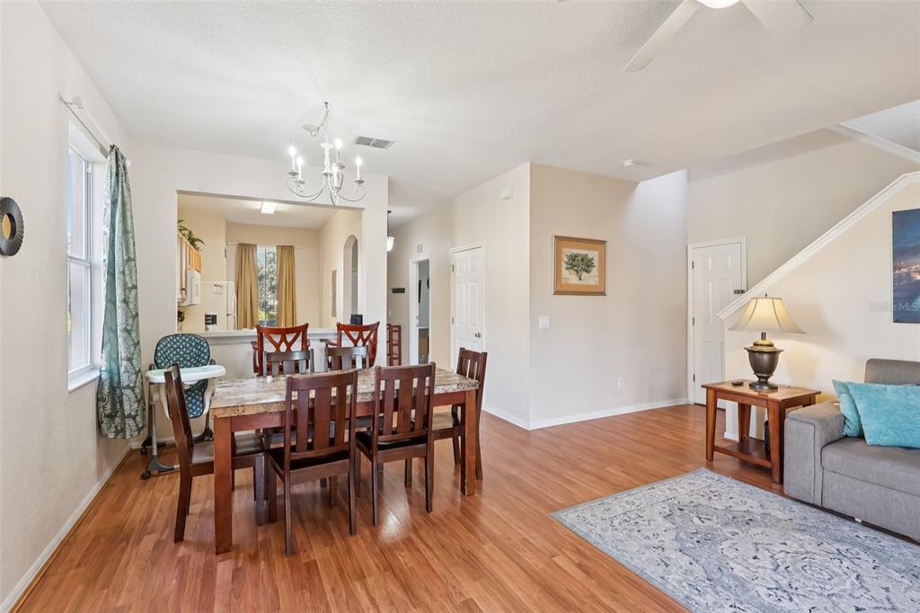 A dining area with a wooden table and chairs sits adjacent to a living room — 353 TERRA LAGO STREET, DAVENPORT, FL