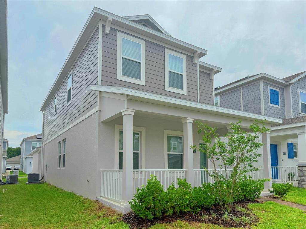 A two-story house with gray siding, a front porch, and a small landscaped yard — 4149 PINO STREET, APOPKA, FL