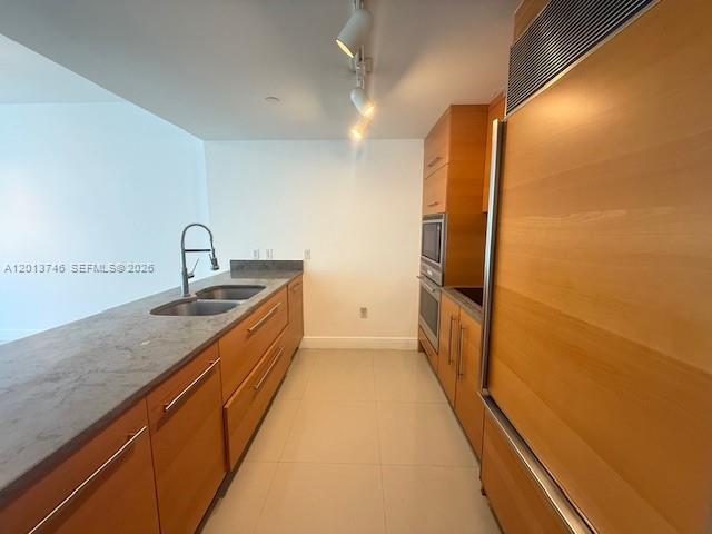 A modern kitchen features light wood cabinetry, gray countertops, and stainless steel appliances — 475 Brickell Ave # 2411, Miami FL 33131, MIAMI, FL